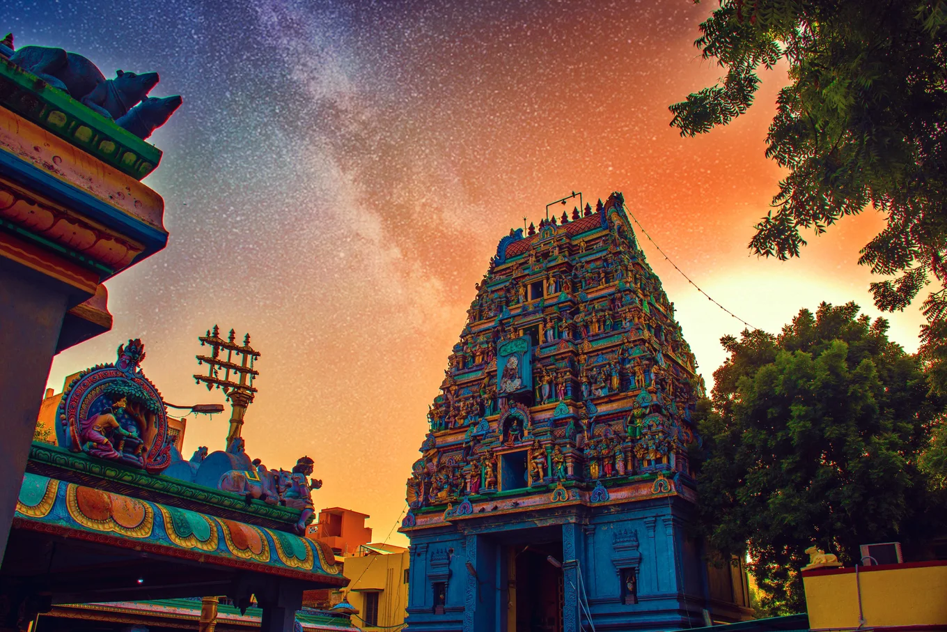 Colorful temple with detailed statues, vibrant sky.