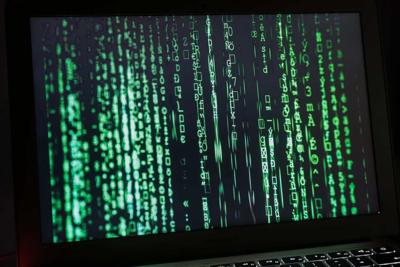 Green digital code on a laptop screen.